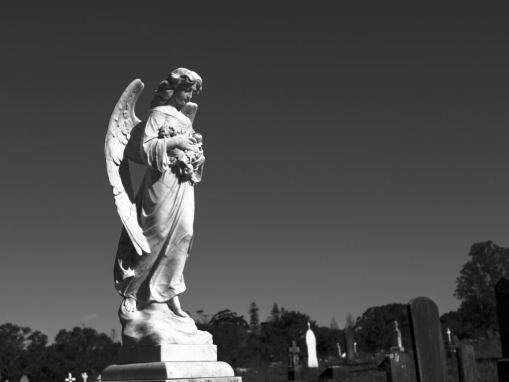 a black and white photo of an angel statue