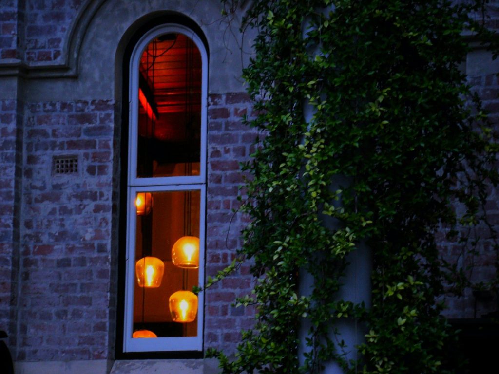 A person standing in front of a window at night
