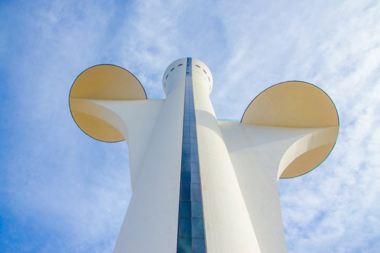 a tall white building with a mickey mouse head on it's side