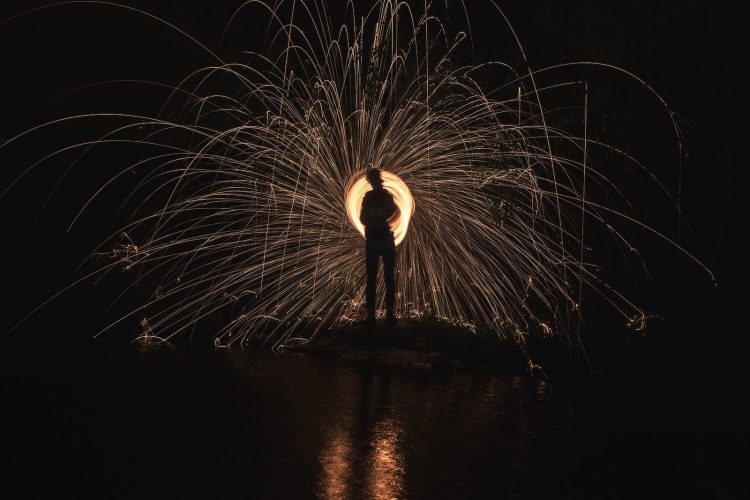 time lapse photography of person standing in front of lights