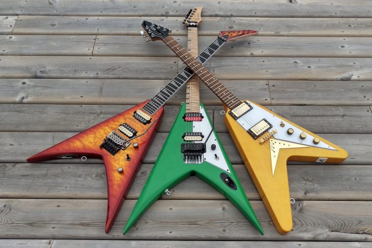 three assorted-color flying V electric guitars
