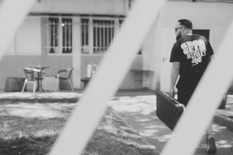 grayscale photography of man carrying case