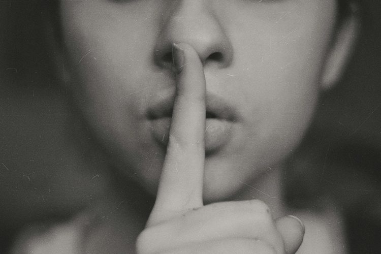 grayscale photo of woman doing silent hand sign