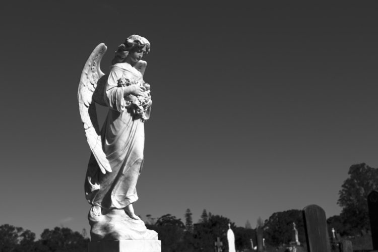 a black and white photo of an angel statue
