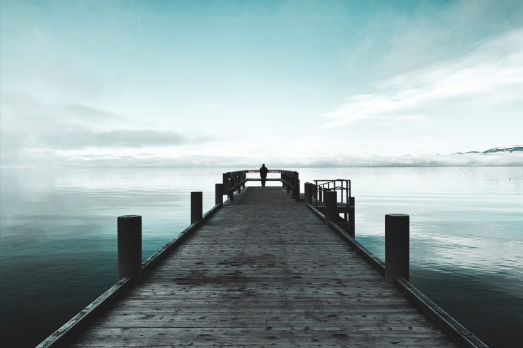 brown wooden dock on sea under blue sky during daytime