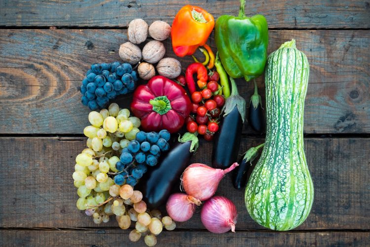 a variety of fruits and vegetables on a wooden surface