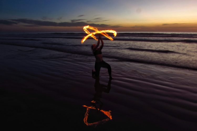 person doing fire dancing on seashore