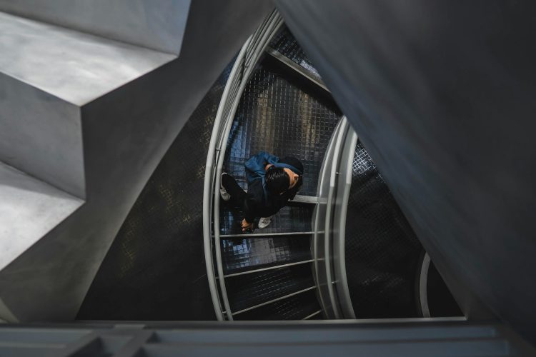 man walking on spiral stairs