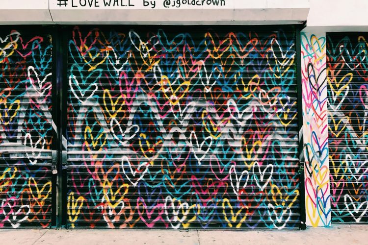 photo of black door shutter filled with heart murals
