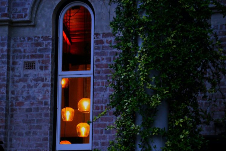 A person standing in front of a window at night