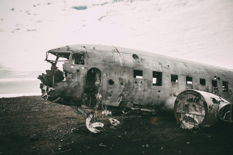 grayscale photo of abandoned airliner in open field