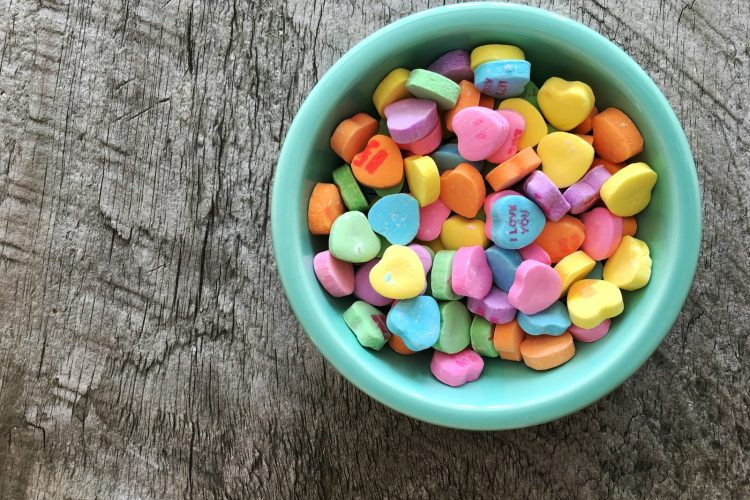 assorted-color heart shape candies on teal bowl