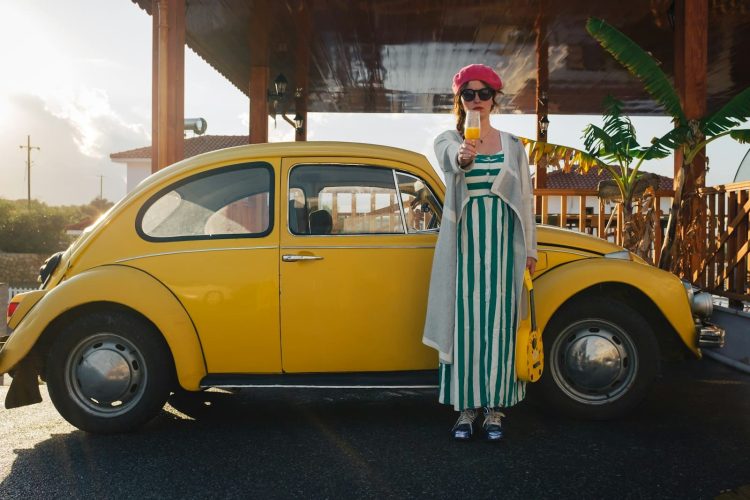 a woman standing next to a yellow car
