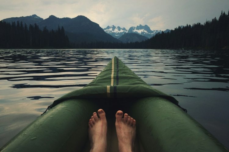 person on top of green kayak